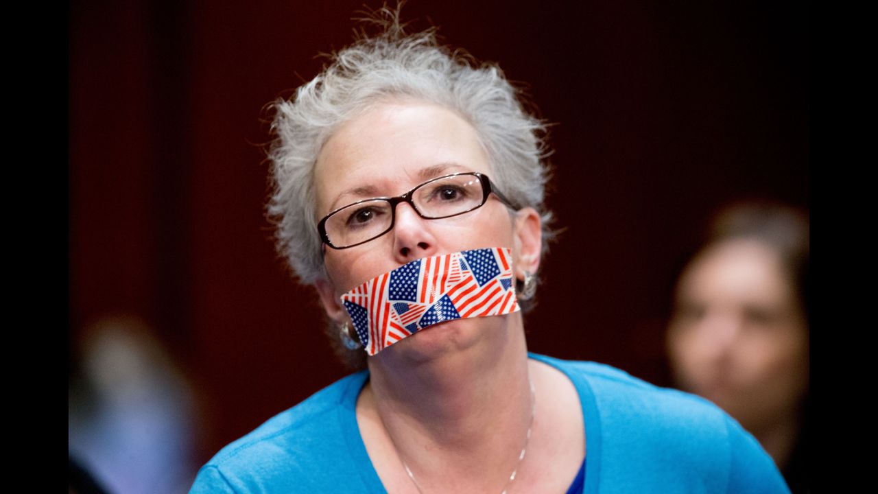 A woman in the audience covers her mouth with tape depicting American flags as CIA Director John Brennan, Director of National Intelligence James Clapper, FBI Director James Comey, National Counterterrorism Center Director Nicholas Rasmussen, National Security Agency Director Adm. Michael Rogers and Defense Intelligence Agency Director Lt. Gen. Vincent Stewart appear at a <a href="http://www.cnn.com/2016/02/25/politics/house-intel-committee-pentagon-isis-files/index.html">House Intelligence Committee hearing</a> on February 25 regarding worldwide threats.