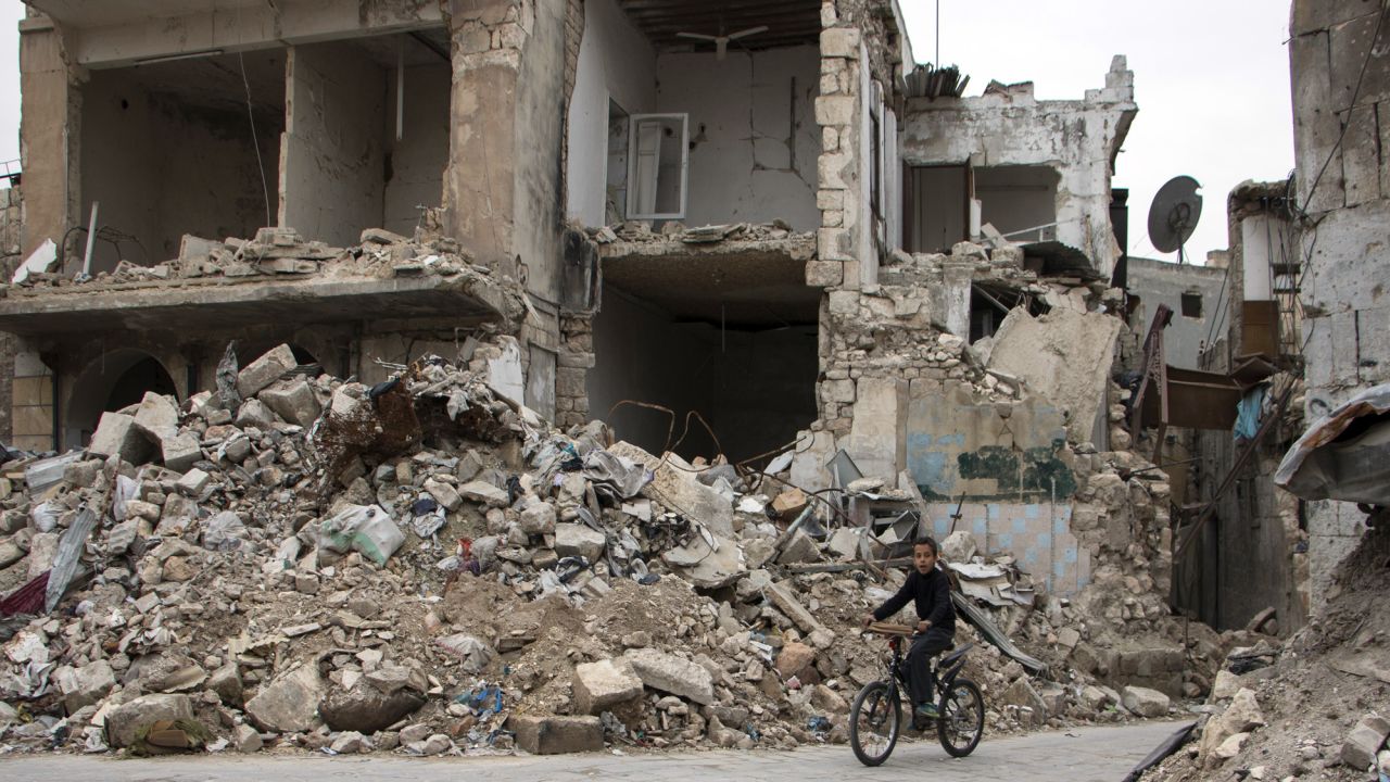 A boy cycles through Aleppo.