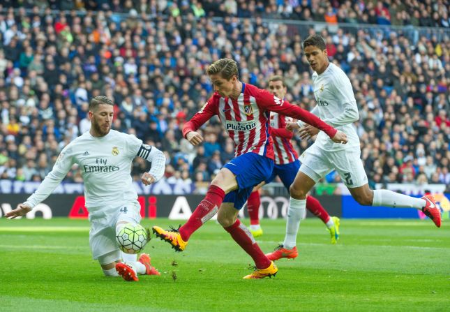 Real Madrid's defender Sergio Ramos (L) vies with Atletico Madrid forward Fernando Torres.