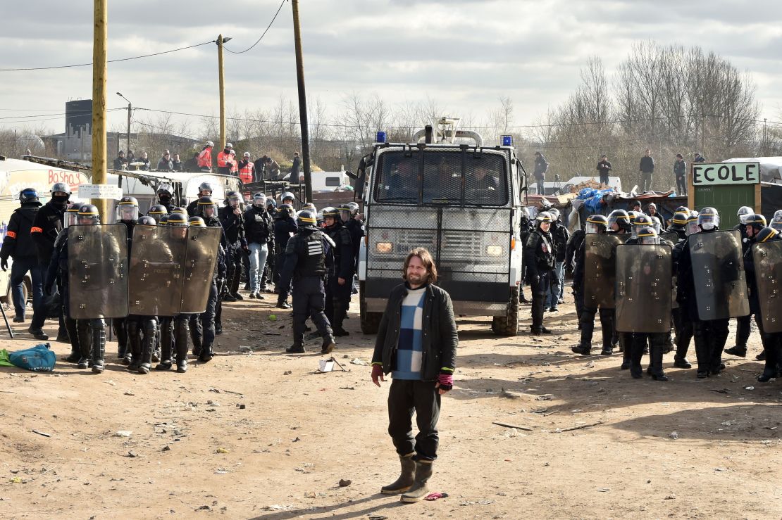 Police forces stand at the ready during the dismantling of half of the "Jungle" migrant camp in the French northern port city of Calais.