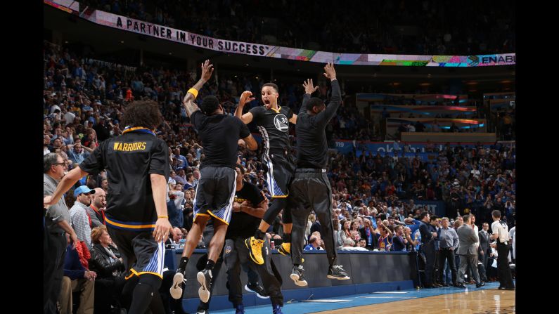 Golden State guard Stephen Curry (No. 30) celebrates with teammates after he hit a long 3-pointer to win in Oklahoma City on Saturday, February 27. Curry made 12 3-pointers in the game and finished with 46 points.
