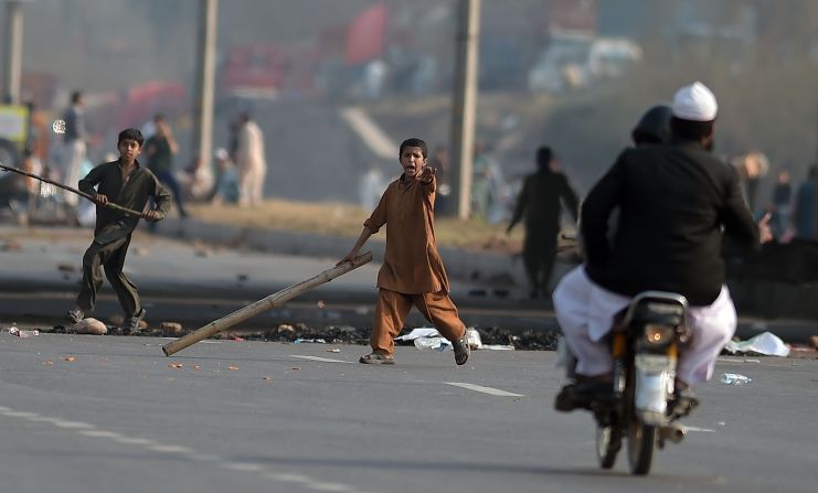Young Pakistani supporters of Qadri carry sticks as they gesture at a motorcyclist on a blocked main highway during a protest against Qadri's execution in Islamabad on February 29, 2016.