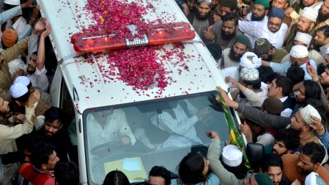 Qadri's supporters gather around the ambulance carrying his body.