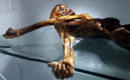 Otzi's left arm covers his throat. 