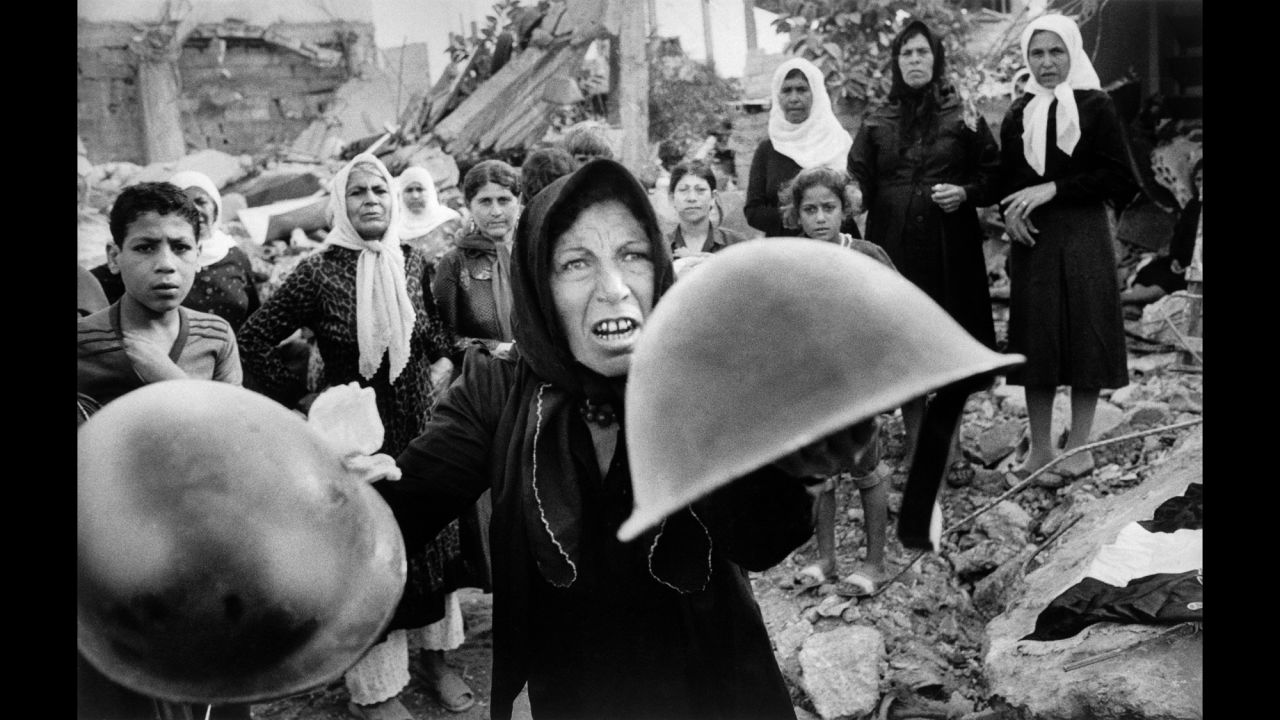<strong>Sabra and Shatila massacre: </strong>In this Pulitzer Prize-winning photo taken September 27, 1982, by Associated Press photographer Bill Foley, a woman holds up helmets that she believes were worn by those who killed hundreds of Palestinians at the Sabra and Shatila refugee camps during the 1982 Israel-Lebanon war. The murders were committed by Lebanese militia members, but an Israeli government inquiry determined Israel was complicit in the massacre.