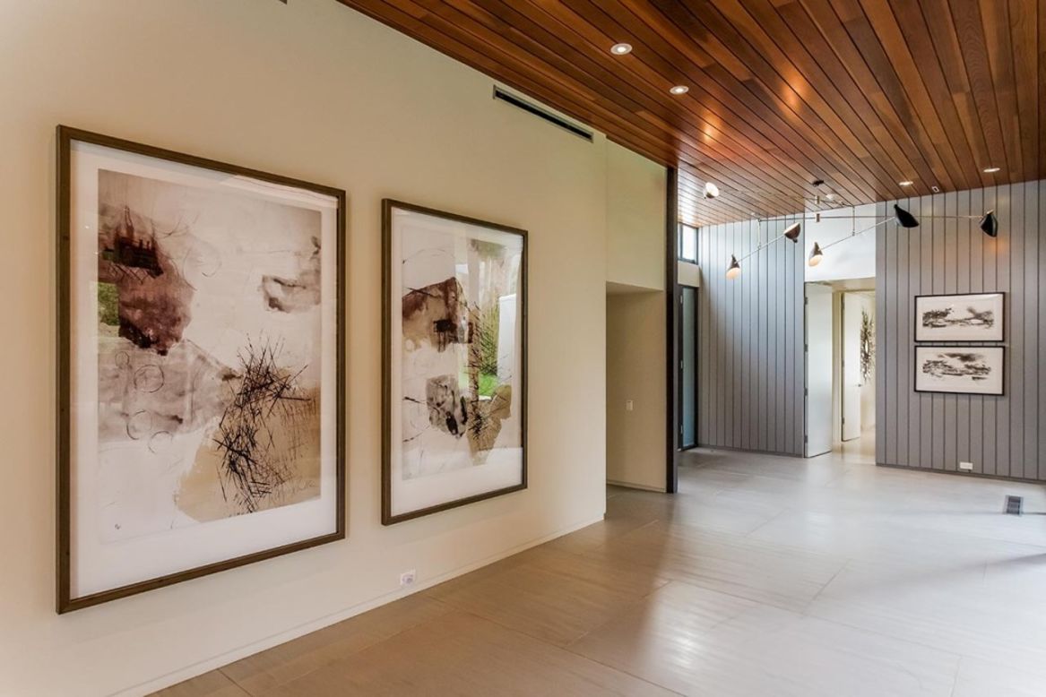 The property's interiors feature floor-to-ceiling glass walls, wooden ceilings and stone walls.