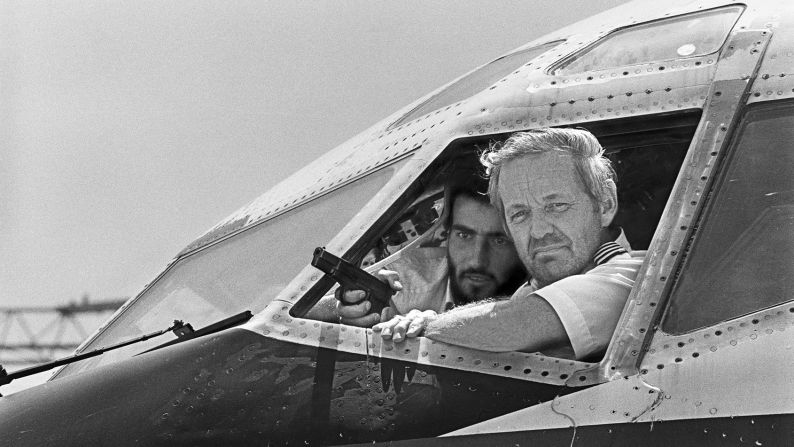 <strong>Terror in the skies:</strong> On June 14, 1985, Shiite terrorists hijacked TWA Flight 847, which was carrying 153 passengers from Athens, Greece, to Rome. The hijacking evolved into a <a href="index.php?page=&url=http%3A%2F%2Fwww.washingtonpost.com%2Fwp-dyn%2Fcontent%2Farticle%2F2007%2F08%2F08%2FAR2007080801122.html" target="_blank" target="_blank">17-day ordeal</a> where passengers were abused and one American was killed. Some hostages were released, and more terrorists boarded as the plane made two round trips between Lebanon and Algeria. All passengers were finally freed on June 30, 1985. <a href="index.php?page=&url=http%3A%2F%2Fwww.nytimes.com%2F1996%2F02%2F07%2Fus%2Fjohn-testrake-68-twa-pilot-who-became-hero-in-hijacking.html" target="_blank" target="_blank">Pilot John L. Testraken</a> -- pictured here talking to reporters at gunpoint -- reportedly kept his cool throughout the entire affair and is widely regarded as a hero.