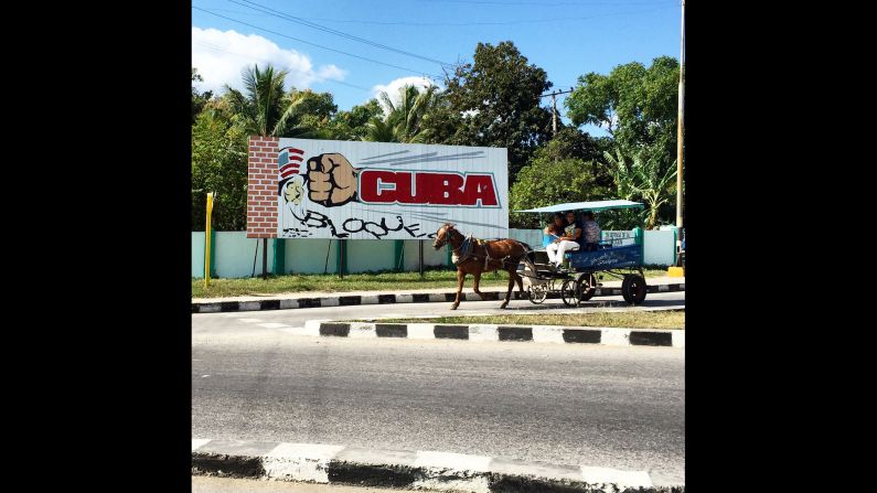 CUBA: "A horse drawn carriage in Cienfuegos travels past a billboard calling for an end to US sanctions on the island. Cuban government propaganda still paints the US as a hostile force but officials here have said they welcome President Obama's visit to the island next month. Almost every Cuban I know is excited for the long delayed thaw in relations that is happening before their very eyes." - CNN's Patrick Oppmann <a href="index.php?page=&url=http%3A%2F%2Finstagram.com%2Fcubareporter" target="_blank" target="_blank">@cubareporter</a>.