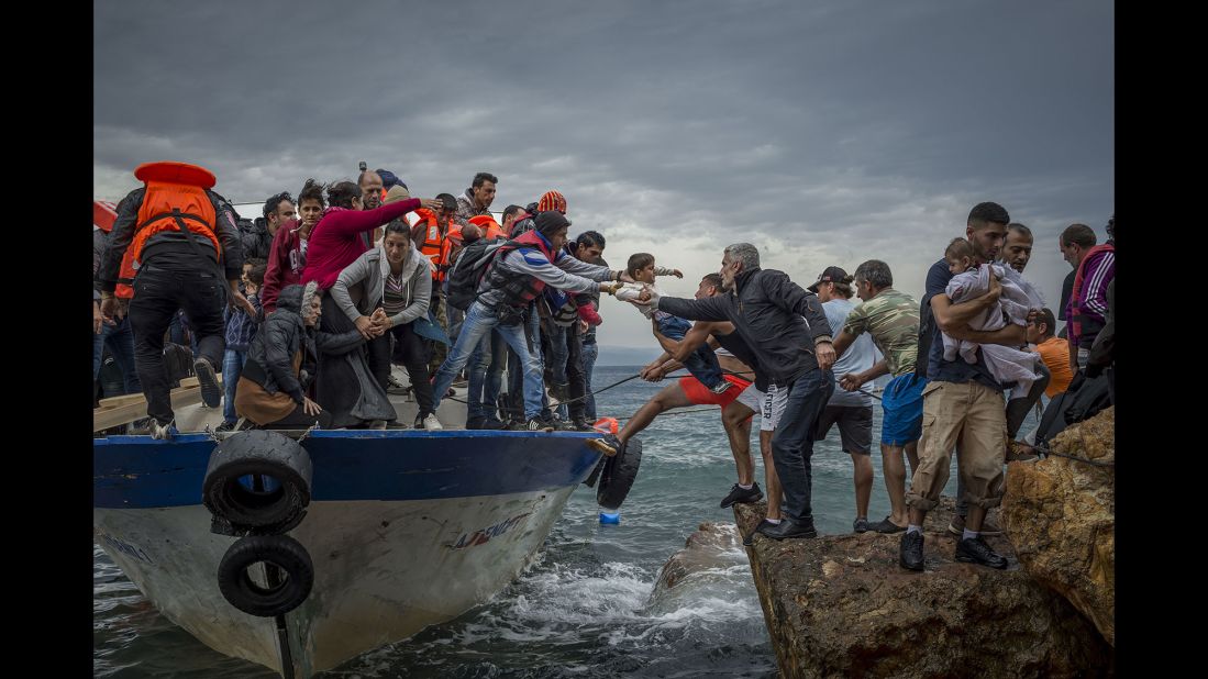 Refugees and migrants get off a fishing boat at the Greek island of Lesbos after crossing the Aegean Sea from Turkey in October 2015.
