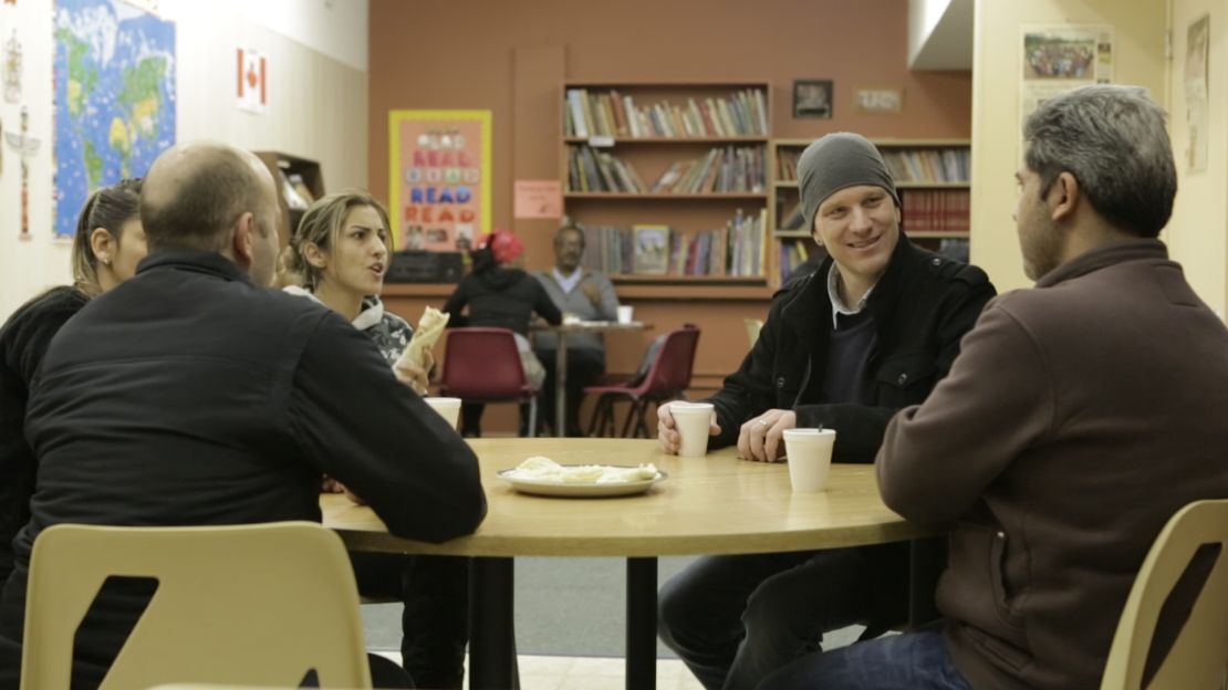 Ryan Dueck, second from right, stops in at a language center for a coffee and conversation with members of the Syrian family his church sponsored.