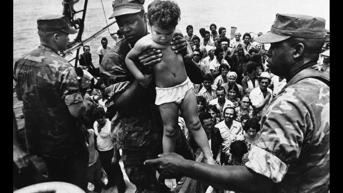 <strong>Mass exodus from Cuba:</strong> Starting in April 1980, more than <a href="http://www.politico.com/story/2009/04/castro-launches-mariel-boatlift-april-20-1980-021421" target="_blank" target="_blank">125,000 Cubans</a> fled from the port of Mariel to Florida. Associated Press photographer Fernando Yovera captured this image of a U.S. Marine lifting a Cuban child off one of the boats that came into Key West on May 10, 1980. Of the 1,700 boats that made the journey from Cuba that year, many were overcrowded, and 27 migrants died before reaching the United States.
