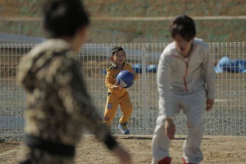 Children play in the dusty playground of a temporary housing complex in Japan's Fukushima prefecture.