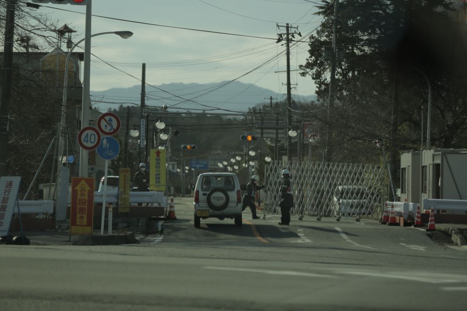 Security guards check passes within the Fukushima exclusion zone, former residents may only visit for up to 5 hours at a time.