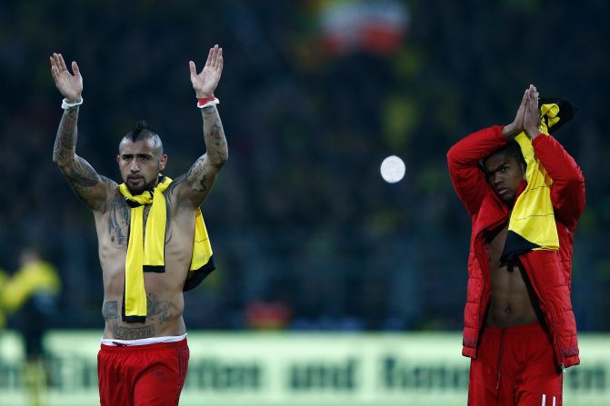Arturo Vidal (L) and Douglas Costa salute fans at the final whistle. The result means Bayern remians five points clear atop the Bundesliga.