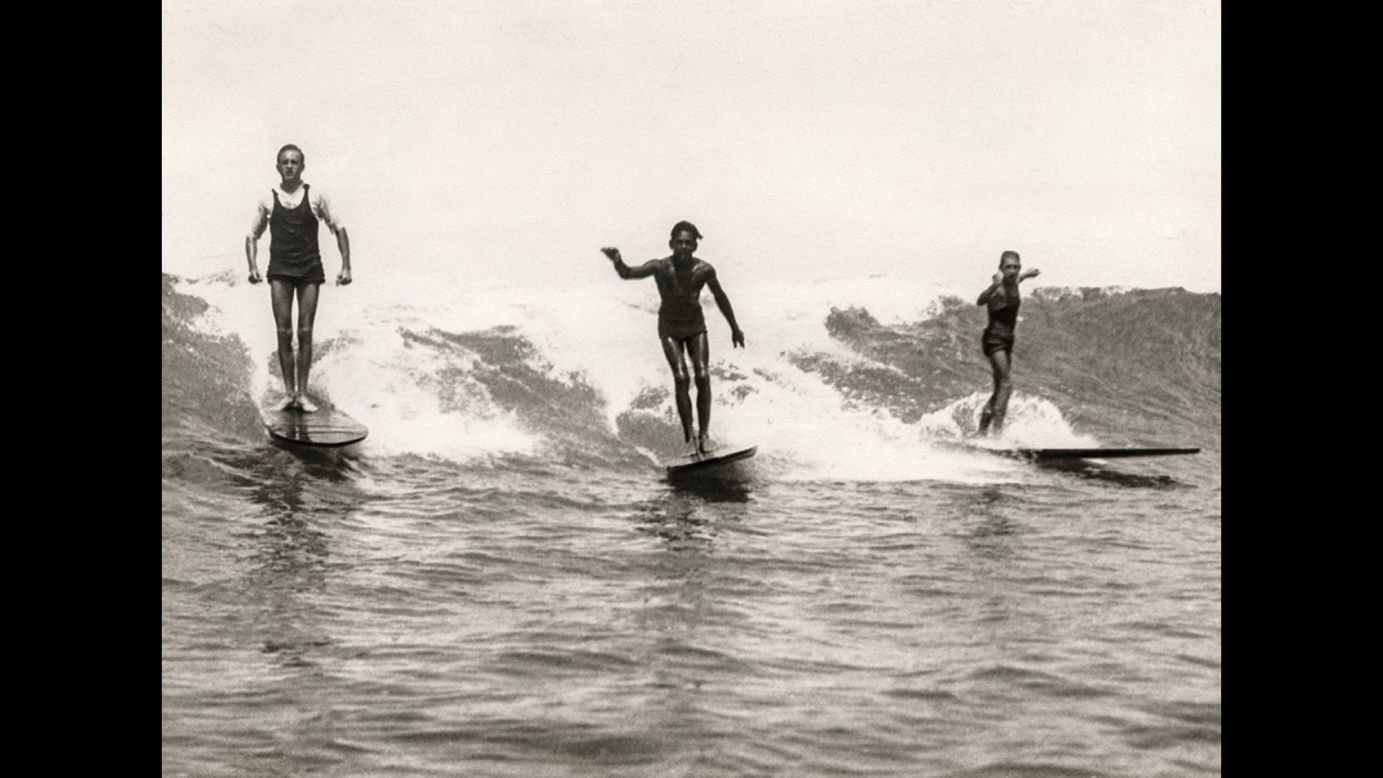 George Freeth, left, surfs at Honolulu's Waikiki Beach around 1907. Freeth is often referred to as the "father of modern surfing." He insisted on riding upright rather than prone, angling across the wave rather than going straight in with the foam.