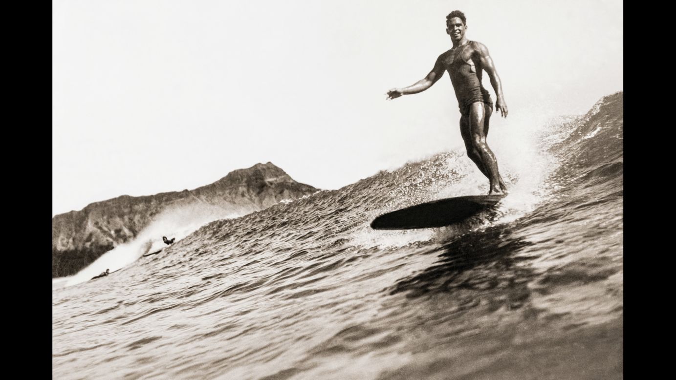This surfer was photographed by Tom Blake around 1932. Blake designed and built the first camera water housings to take close-up surfing photographs. He would wade out and stand on the shallow reef at Waikiki or take a canoe out to deeper water. A surfer himself, Blake had a natural eye for framing the wave and the rider in a way that caught the peak of action.