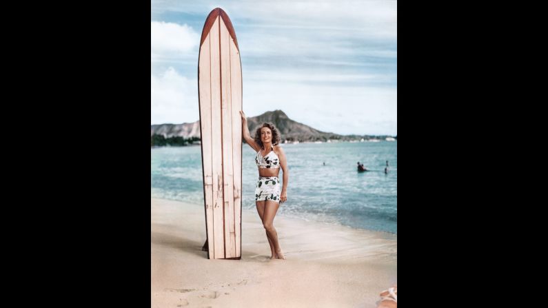 Actress Joan Crawford poses with a surfboard in Waikiki around 1946. Surfboards provided a convenient prop for glamorous Hollywood movie stars visiting Hawaii.