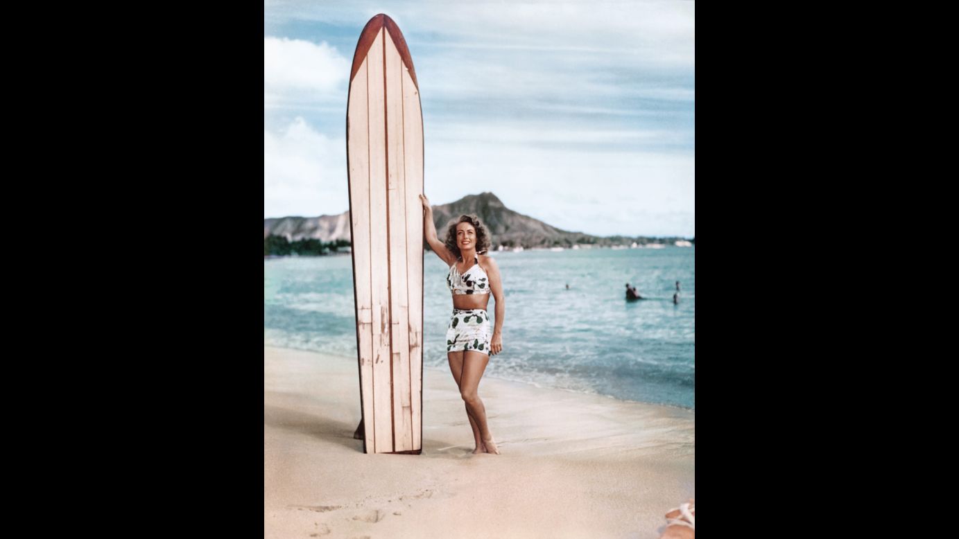 Actress Joan Crawford poses with a surfboard in Waikiki around 1946. Surfboards provided a convenient prop for glamorous Hollywood movie stars visiting Hawaii.