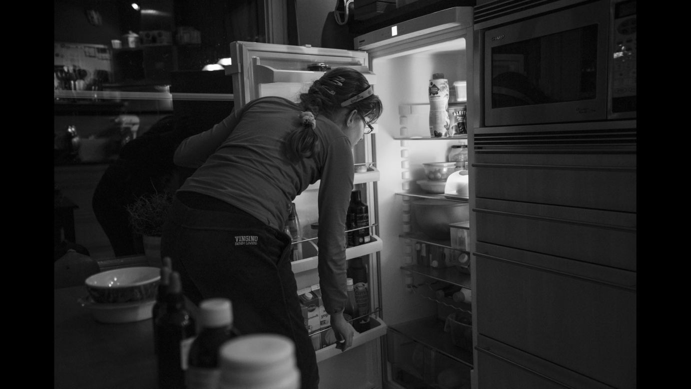 Suzanne looks in the fridge for a healthy snack that she's allowed to have in the afternoon. She has been on a limited diet since age 2.