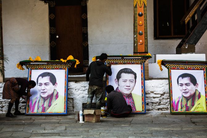 Workers at the Punakha Dzong temple prepare portraits of Bhutan's fourth and fifth kings as part of the fourth king's 60th birthday celebration. Known as "K4," Jigme Singye Wangchuk introduced democracy and the concept of Gross National Happiness.