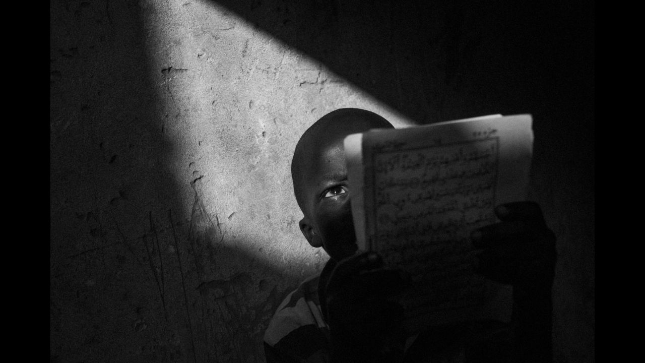 A talibé reads the Quran inside a school in Dakar. 