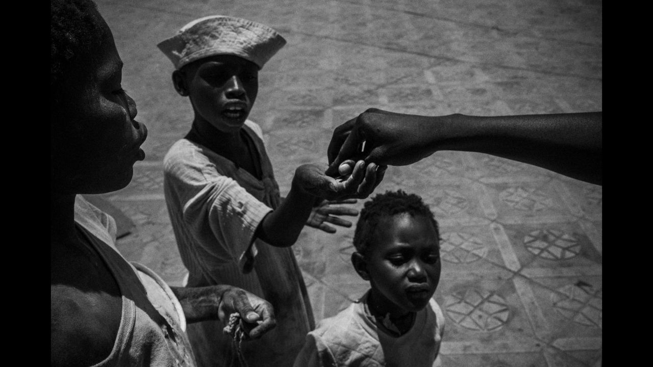 A man gives money to talibés in Touba, Senegal.