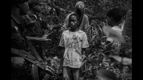 Military police approach a group of children walking through a forest area near the Guinea-Bissau border. Cruz learned that many talibés are kidnapped and trafficked from Guinea-Bissau.