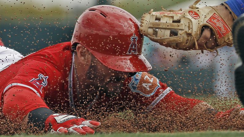 Johnny Giavotella, a second baseman with the Los Angeles Angels, slides safely into third after hitting a triple in Tempe, Arizona, on Sunday, March 6.
