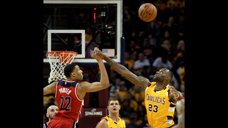 Otto Porter Jr. and LeBron James reach for a loose ball during an NBA game in Cleveland on Friday, March 4.