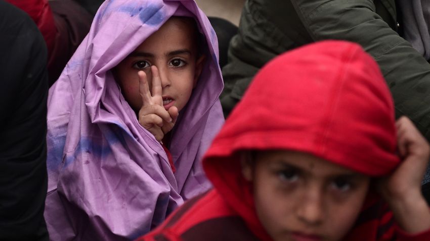 A young boy wrapped in a blanket to protect him from the rain gestures as migrants and refugees protest to call for the opening of the borders near the village of Idomeni where thousands of refugees and migrants are stranded on March 7, 2016. 
EU leaders held a summit with Turkey's prime minister on March 7 in order to back closing the Balkans migrant route and urge Ankara to accept deportations of large numbers of economic migrants from overstretched Greece. / AFP / LOUISA GOULIAMAKI        (Photo credit should read LOUISA GOULIAMAKI/AFP/Getty Images)