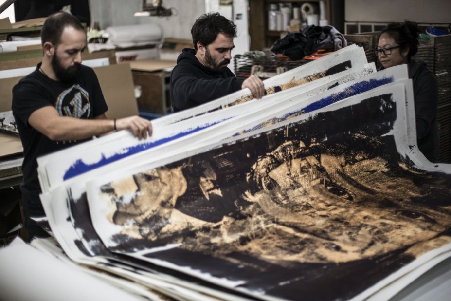 Vhils and his studio manager checking silkscreen prints at a factory in Hong Kong ahead of his exhibition Debris. 