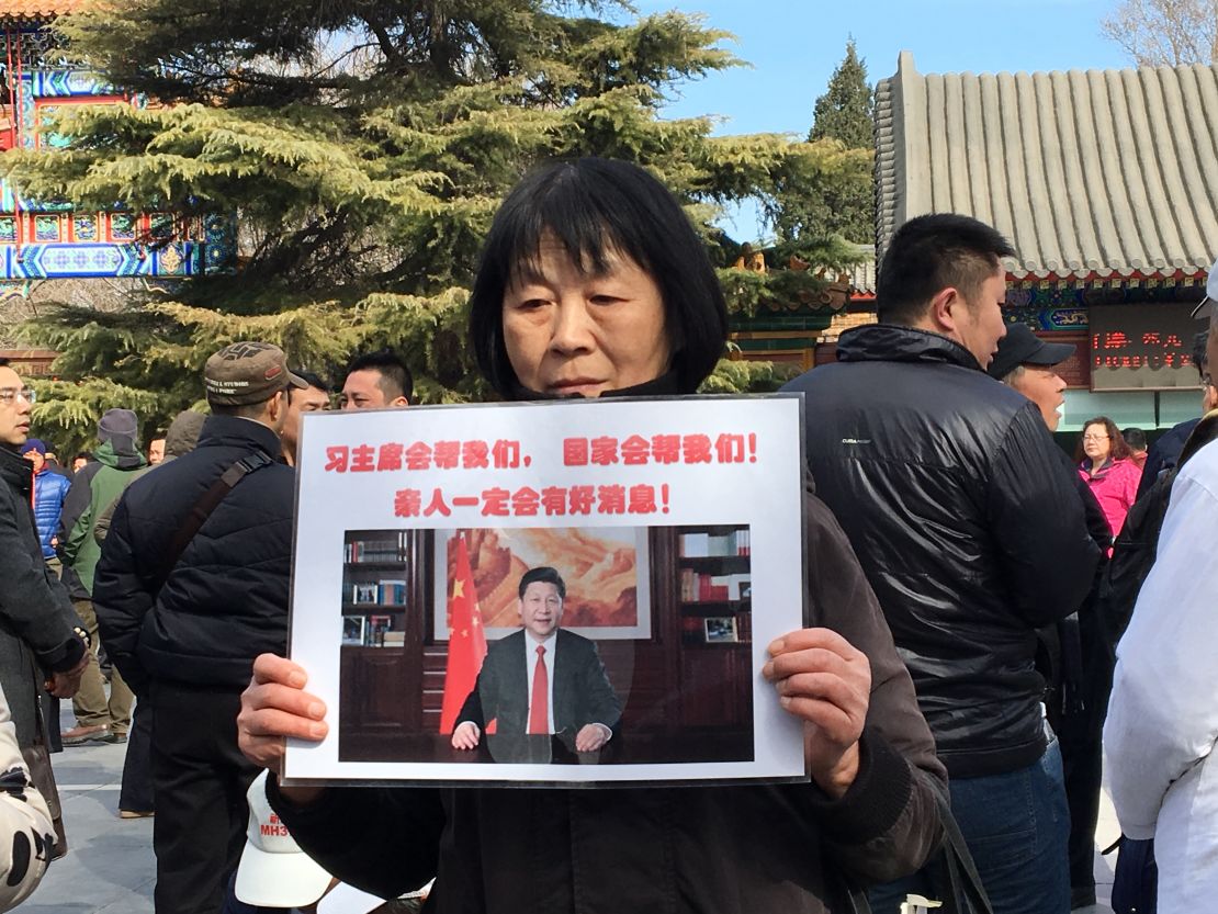 Dai Shuqin's sister's family of five were on MH370. The piece of paper she holds up reads: "President Xi will help us! The country will help us. There will be good news about our loved ones." 