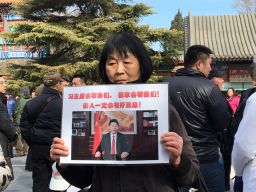 Dai Shuqin's sister's family of five were on MH370. The piece of paper she holds up reads: "President Xi will help us! The country will help us. There will be good news about our loved ones." 