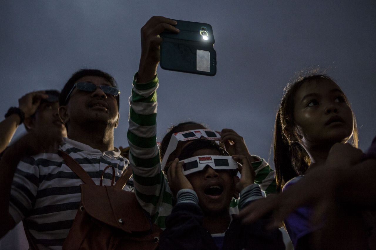 Special filters are needed in order to view the sun safely. Here, a crowd in Palembang city in Indonesia's South Sumatra province gather for the event. 