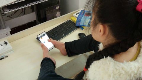 Sun Lukang types on her smart phone with two toes. She has published four books since 2005.