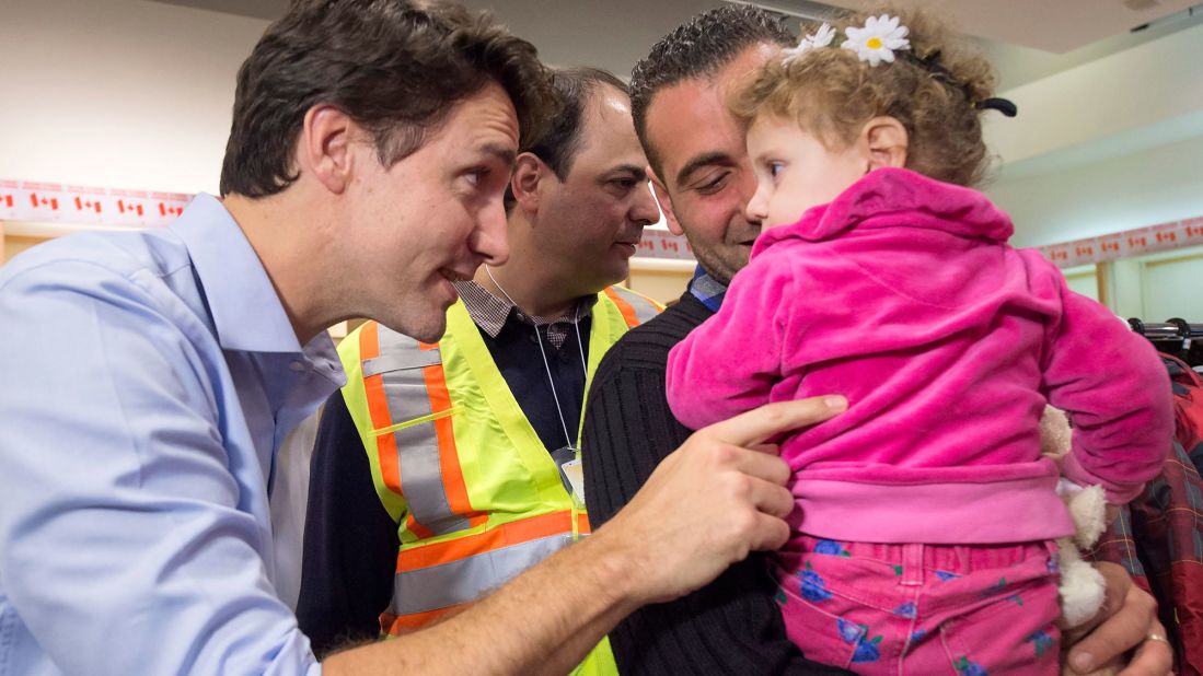 Trudeau greets Syrian refugees Kevork Jamkossian and daughter Madeleine during their arrival at Toronto's Pearson International Airport in December 2015. The new Prime Minister pledged to take in and resettle 25,000 Syrian refugees in Canada.