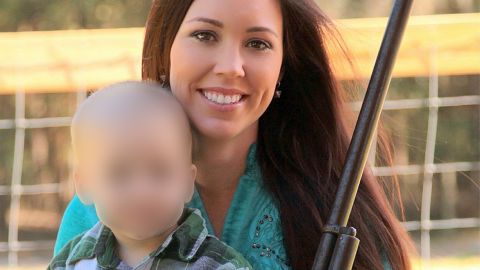 Jamie Gilt poses with a gun and small child. 