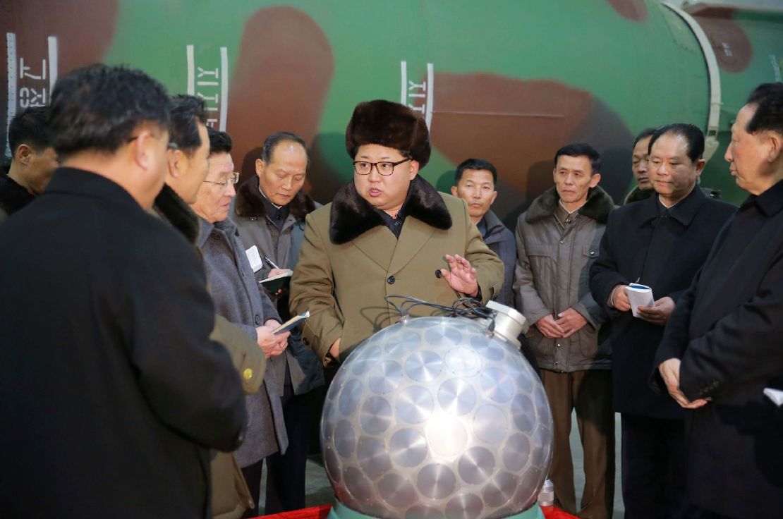 In an undated photo, Kim Jong Un gathers with nuclear weapons scientists and technologists around what North Korea claimed was a miniaturized nuclear warhead.
