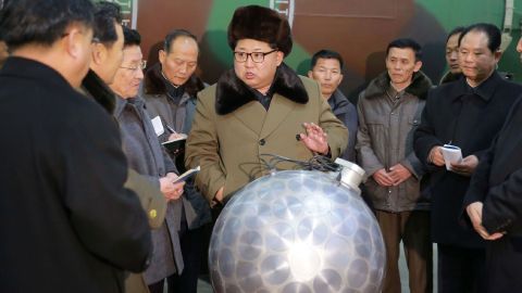 In an undated photo, Kim Jong Un gathers with nuclear weapons scientists and technologists around what North Korea claimed was a miniaturized nuclear warhead.