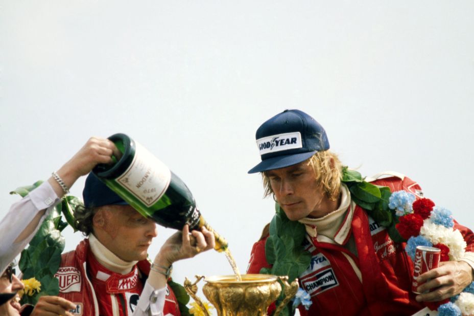 Lauda watches as champagne is poured into Hunt's trophy at the 1977 British Grand Prix at Silverstone. 