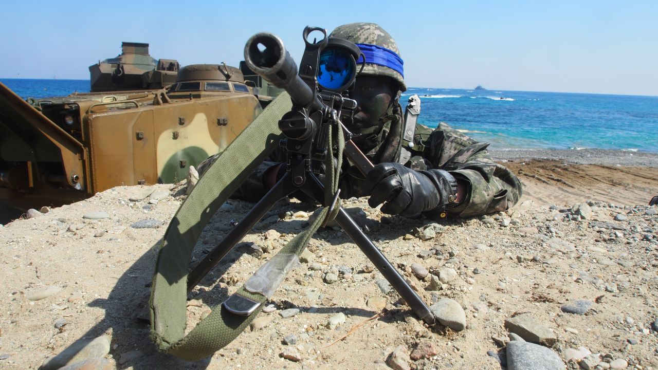 A South Korean Marine looks through a viewfinder on a sniper rifle on March 12. Marines and sailors stormed a beach aboard assault vehicles in a mock amphibious assault.