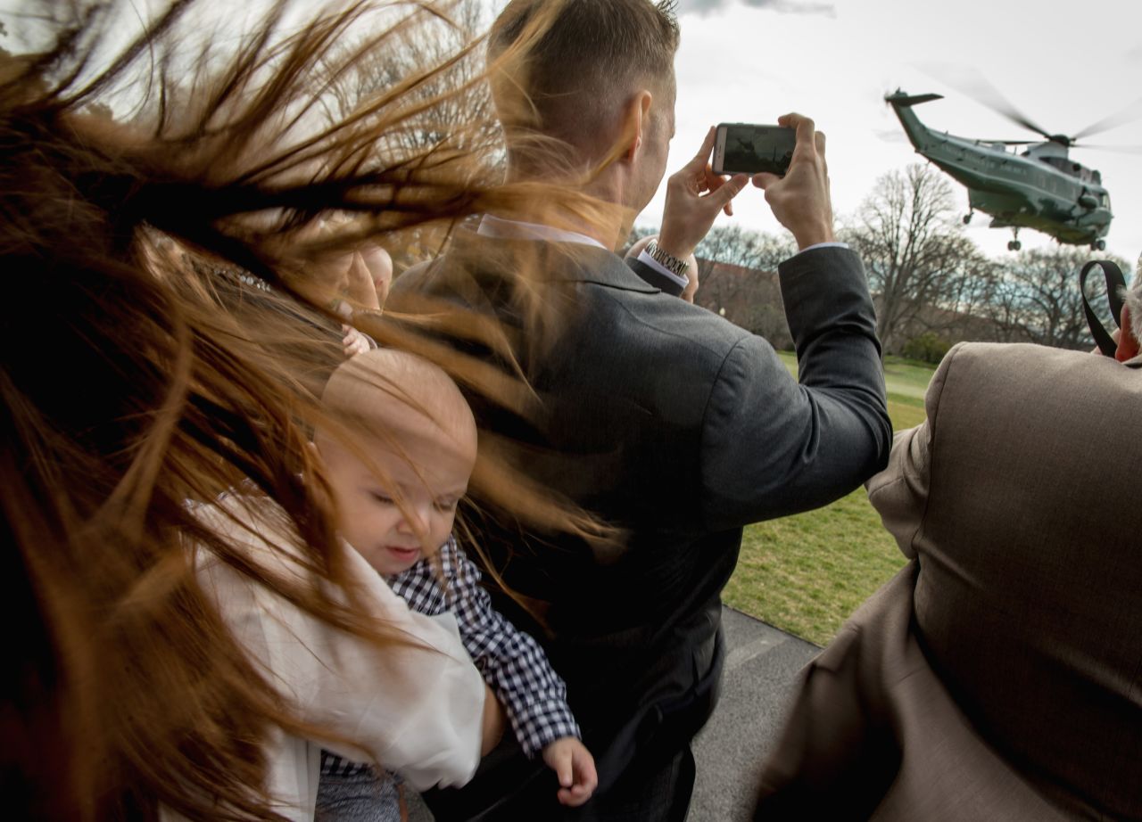 Lynel Zimmerman holds her baby, James Thompson, as Marine One takes off from the South Lawn of the White House with President Barack Obama aboard in Washington, on Friday, March 11.