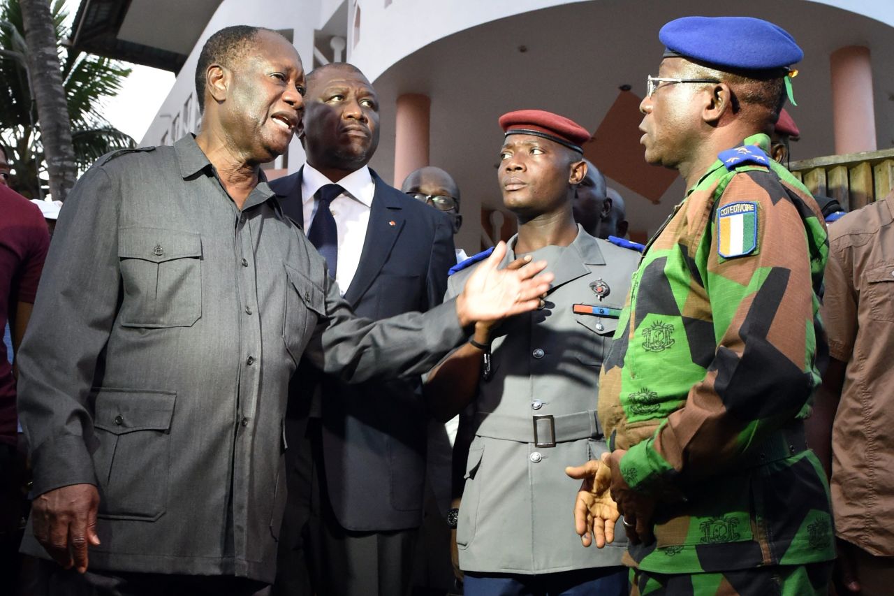 Ivory Coast President Alassane Ouattara, left, speaks to the country's chief of staff, Gen. Soumaila Bakayoko.