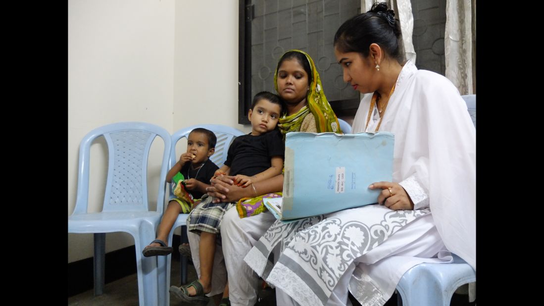 Nasima Begum and her son, Mohommad Mustakim, talk with a researcher while her younger son, Amin, has a snack. The family participated in a clinical study in Dhaka, Bangladesh, that tested the efficacy of the rotavirus vaccine. Rotavirus is a major cause of severe diarrhea worldwide, but the vaccine doesn't work well in Bangladesh and other low-income countries, and researchers are trying to find out why. 