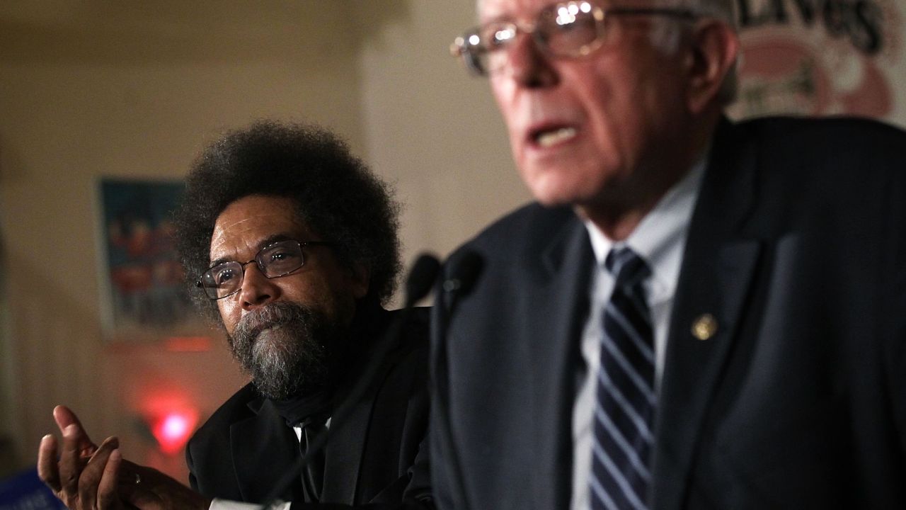 Democratic presidential candidate Sen. Bernie Sanders speaks to voters as philosopher and social activist Cornel West listens during a campaign rally in Iowa.