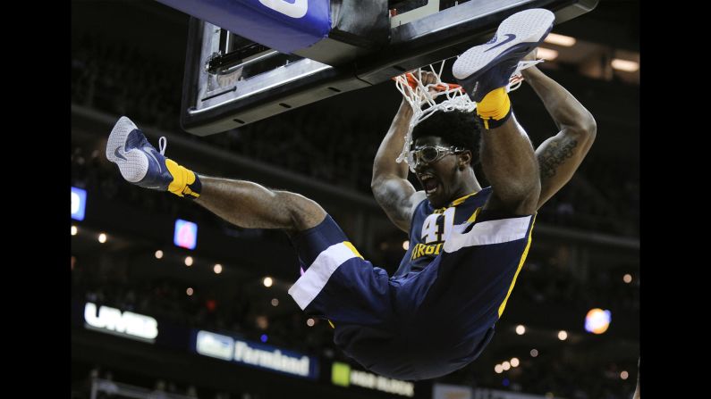 Devin Williams of the West Virginia Mountaineers hangs on the rim after dunking against the Kansas Jayhawks in the first half during the championship game of the Big 12 Basketball Tournament on Saturday, March 12, in Kansas City, Missouri. 