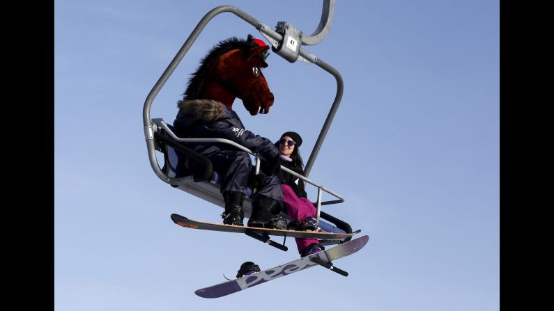 A snowboarder wearing a horse head mask rides a lift uphill at the Bobrovy Log ski resort in the suburbs of Krasnoyarsk in Russia's Siberia on Sunday, March 13. 
