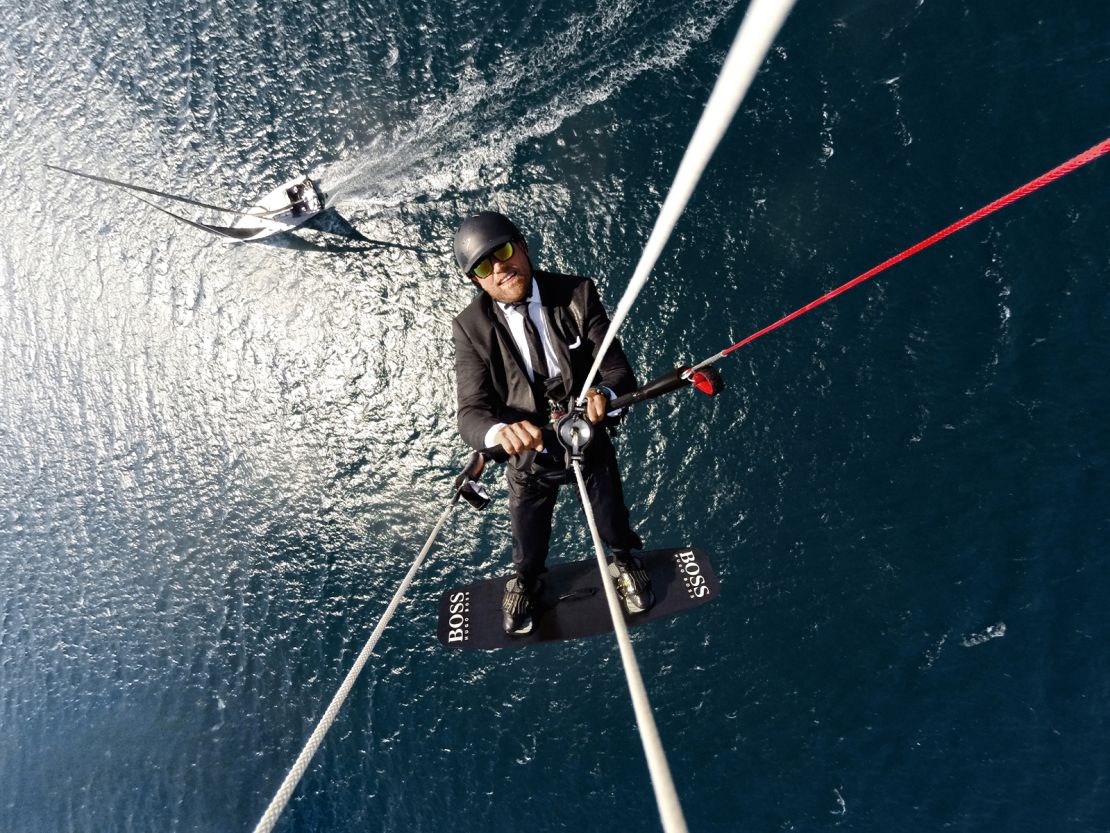 Thomson kite surfs high above his Hugo Boss yacht in a publicity stunt.