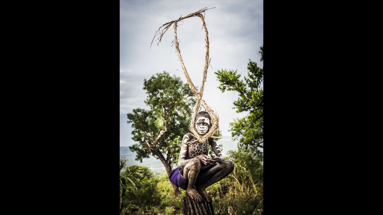 It took Seton three days of driving from Addis Ababa to photograph the Suri tribe, who reside in Naregeer village in the Upper Omo Valley -- a remote area of Ethiopia close to the border of South Sudan. In this first photograph of the day, shot at 6 a.m., a boy balances on a tree trunk in a sorghum field.
