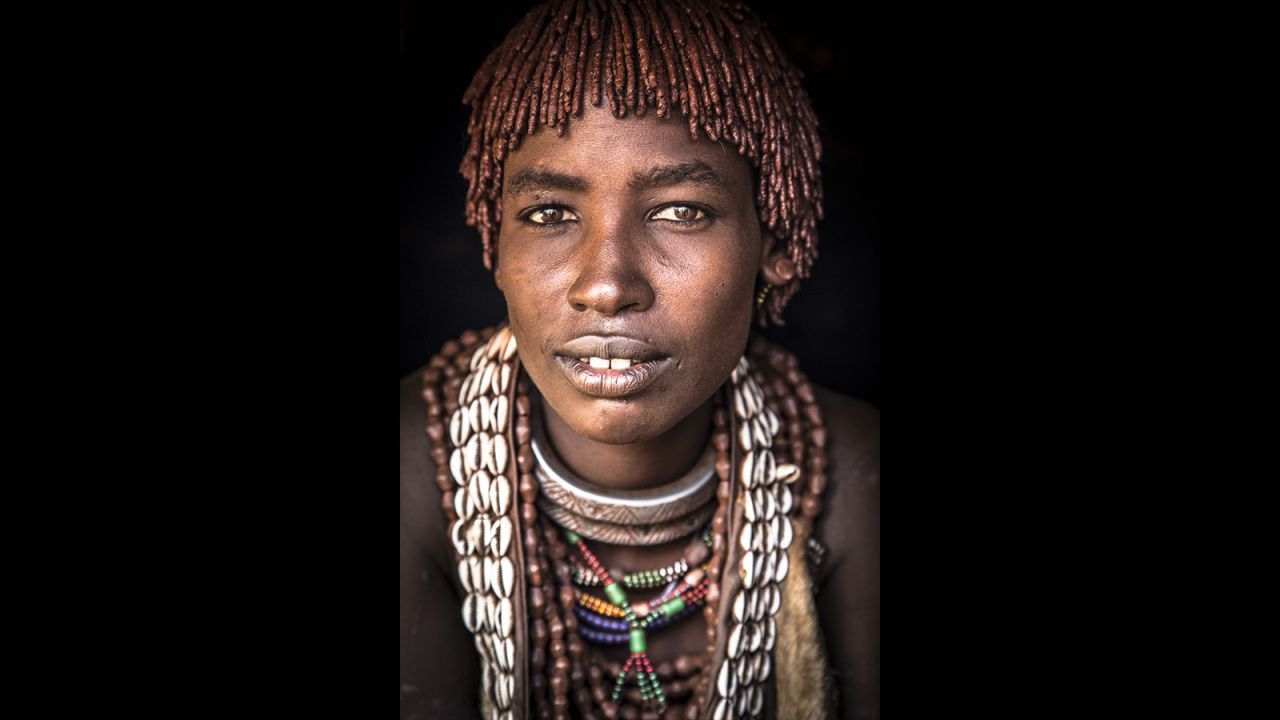 Depending on their social status and other factors, Hamar men can have up to three wives. A Hamar woman's status can be immediately identified by her jewelry. The first wife, pictured here, wears a large metal necklace with a long thorn on its end. The second and third wives wear simpler, round metal necklaces.